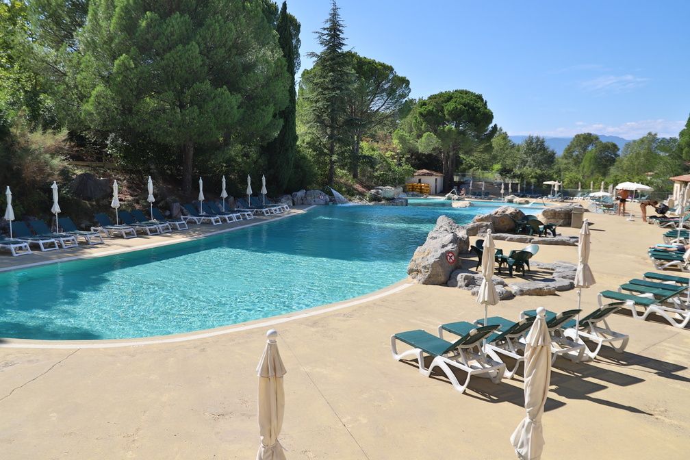 image Wide outdoor pool with sun loungers under the trees — the starting point for most afternoons here.