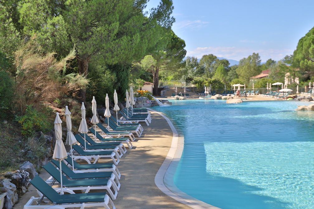 image Pool deck lined with umbrellas and loungers, steps from the restaurant and game room on-site.