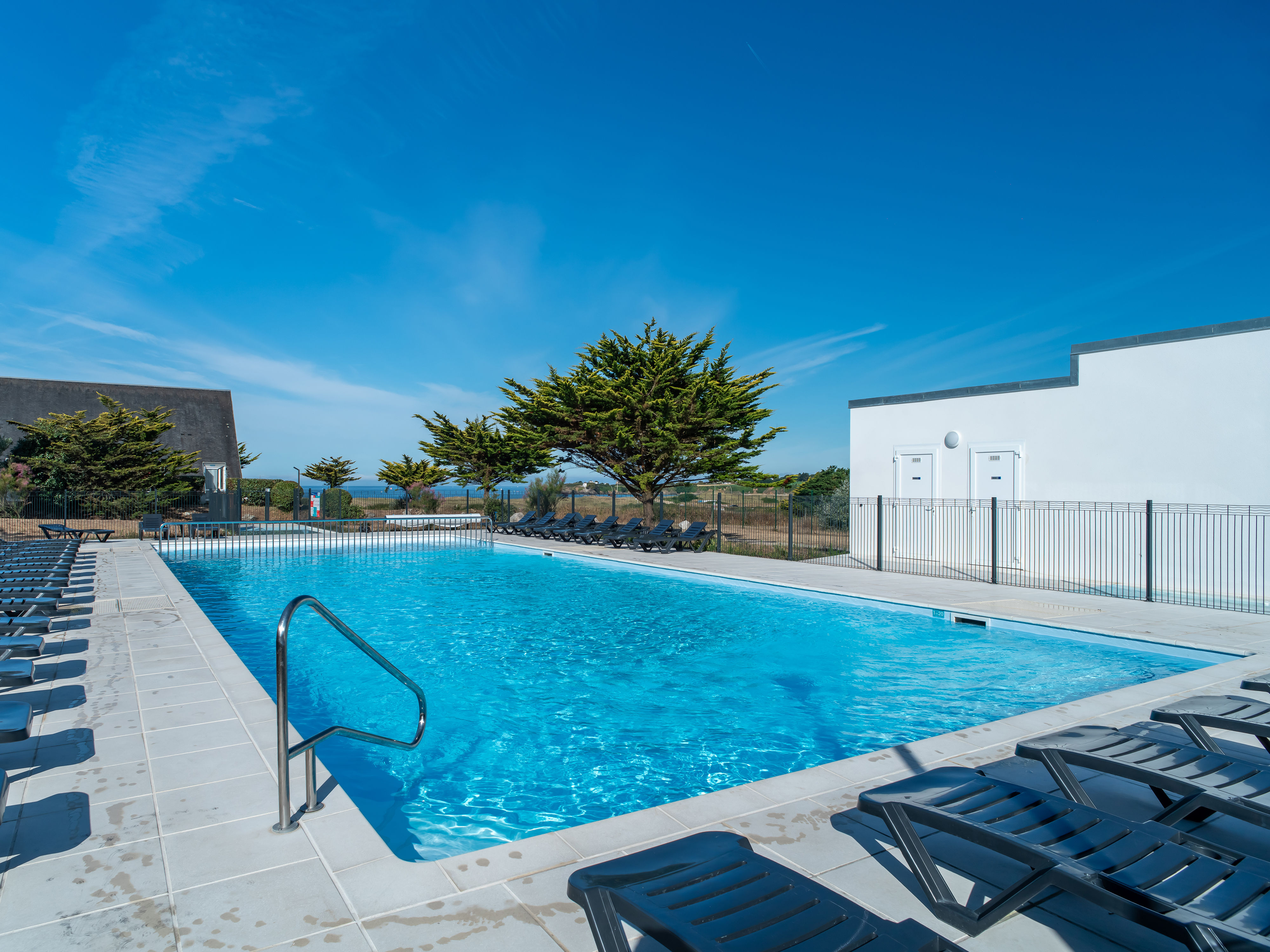 image Wide shot of the pool terrace, with lounge chairs and open space for the whole group