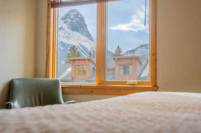 Gaze out at the striking mountain peaks through the cozy window, inviting you to explore the outdoors.