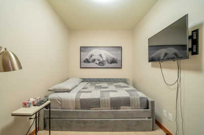 Experience a restful retreat in this snug bedroom, complete with a soft quilt and warm accents, ready for your stay.