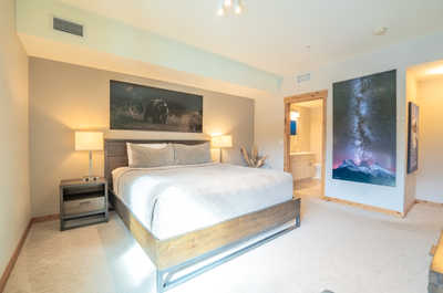 Relax in this inviting bedroom, featuring a plush king-sized bed and warm lighting.