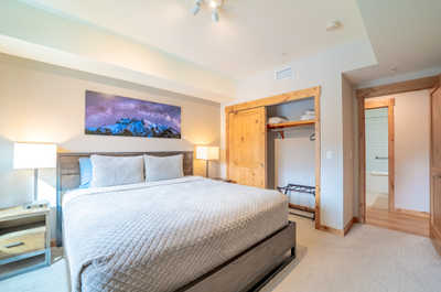 Sink into a luxurious king-size bed, surrounded by soft textures and warm wood accents.