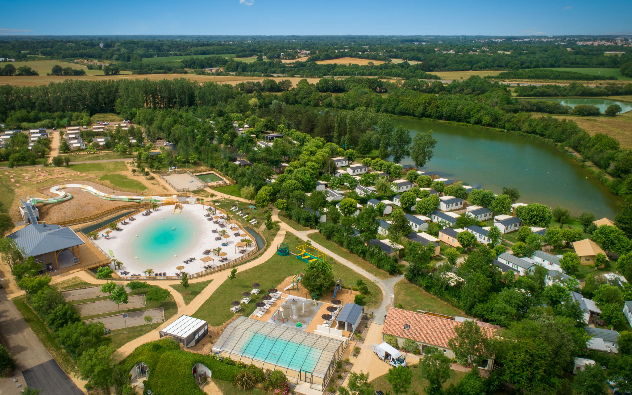 image An aerial view of a luxurious pool and lake setting.