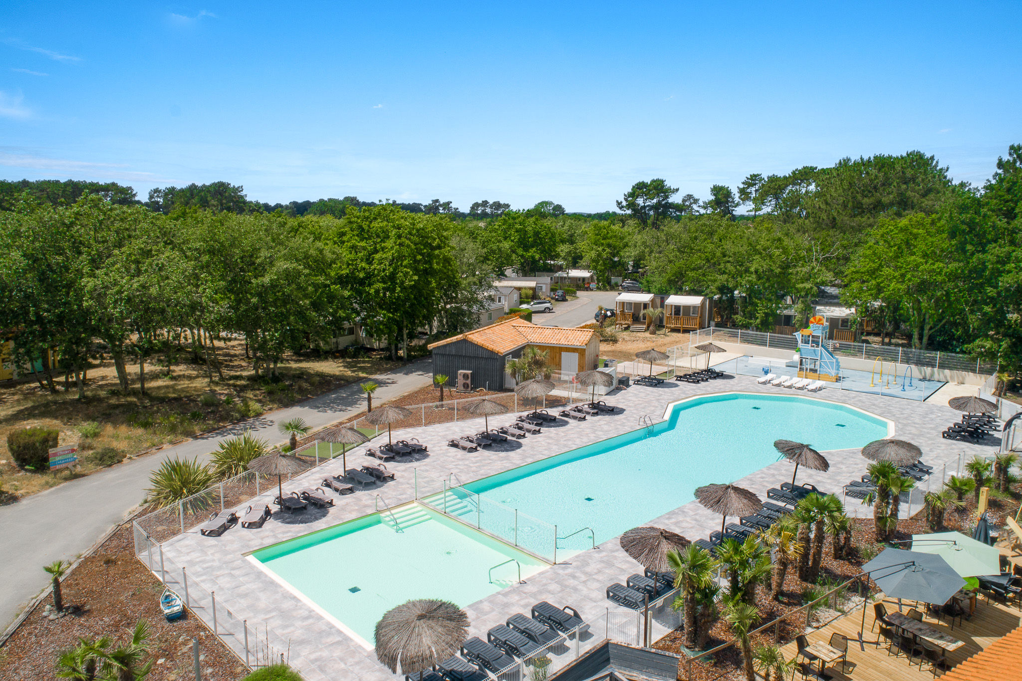 image Large swimming pool area with ample seating and sun umbrellas, creating a resort-like ambiance.