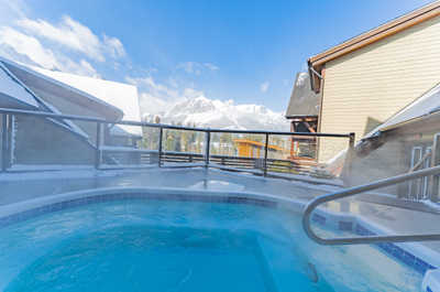 Hot tub with mountain and building views