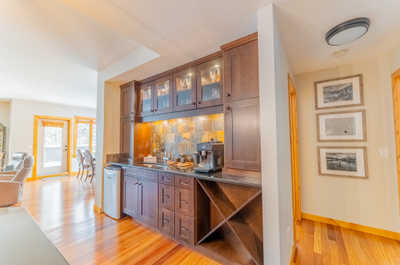 Kitchen with dark cabinetry, bar area, and appliances