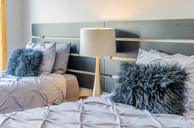 Bedroom with two beds, decorative pillows, and a lamp