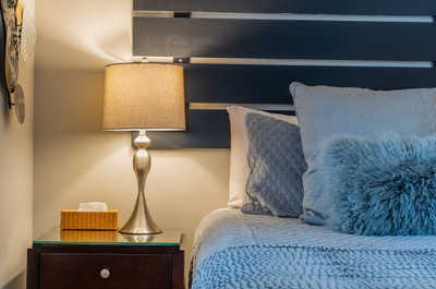 Bedroom corner with lamp, pillows, and tissue box