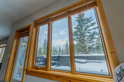 Large windows with wooden frames and snowy mountain view