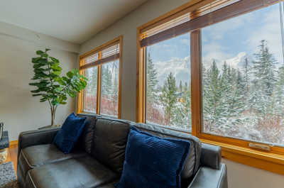 Sofa with blue pillows and snowy mountain views outside