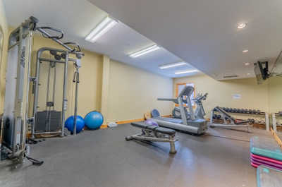 Shared fitness room with exercise machines and weights