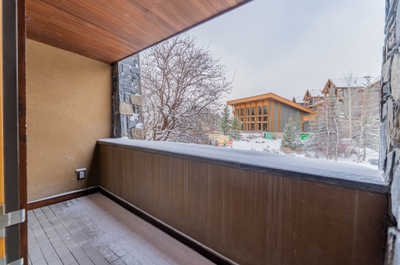 Private deck from the master bedroom with snow-covered trees and building views