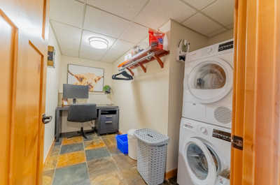 Laundry room with washer, dryer, desk, and wall decor