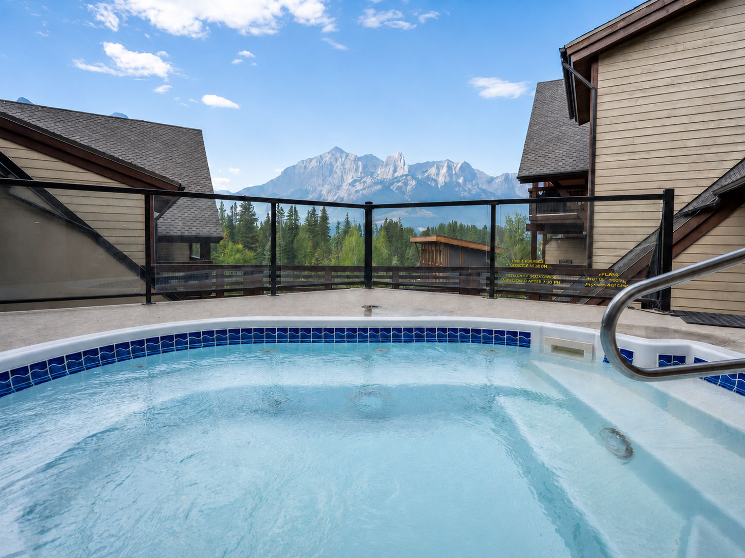 image Hot tub on deck with mountains and trees visible in background
