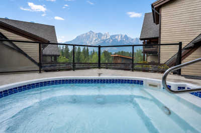 Hot tub on deck with mountains and trees visible in background