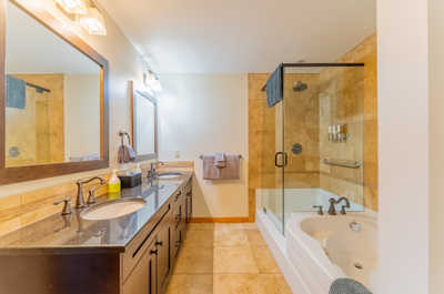 En-suite bath with dual sinks and glass-enclosed shower