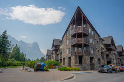 Ground-level view of stone building with mountain backdrop