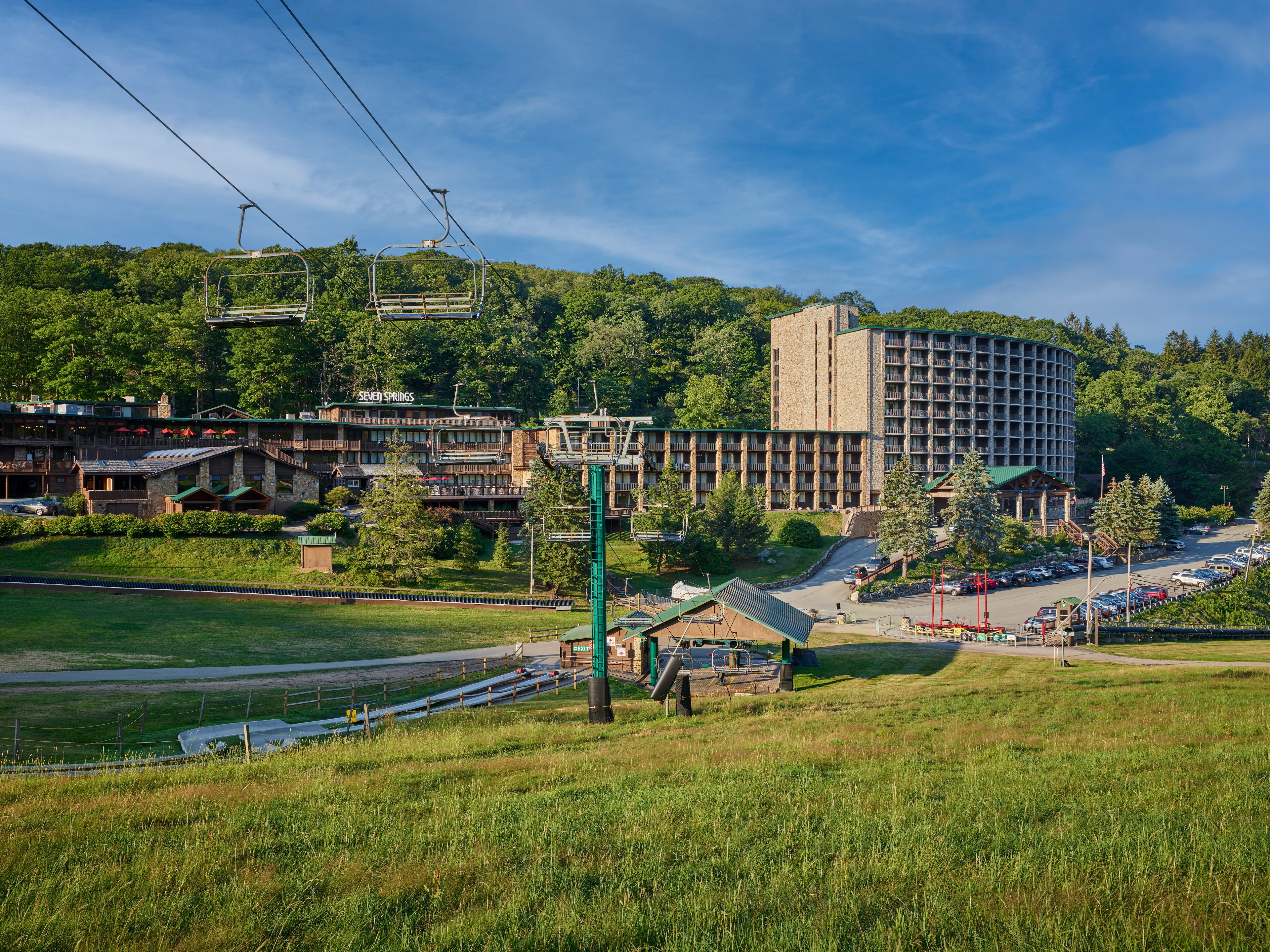 image Nestled in lush greenery, the inviting mountain landscape beckons with adventure and tranquility under a bright blue sky.