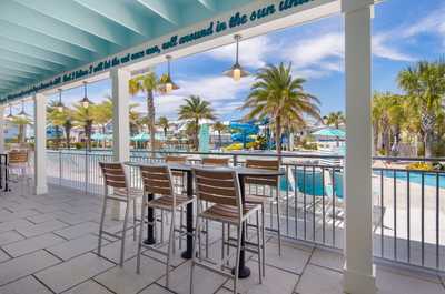 Kick back at high-top tables overlooking the vibrant pool and waterslide, perfect for sunny days.