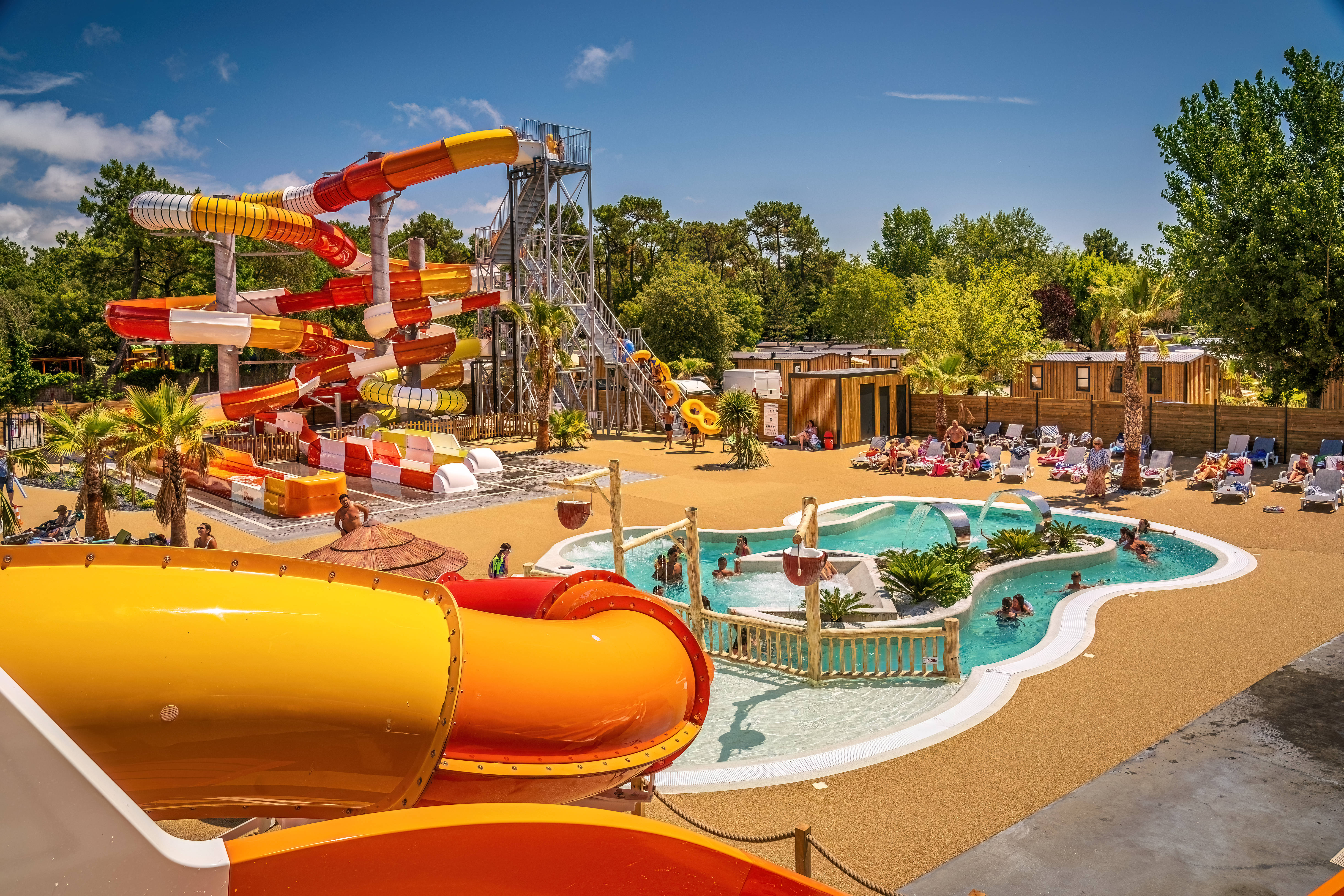 image Vibrant pool area with multiple slides and splash features, offering fun for all ages.