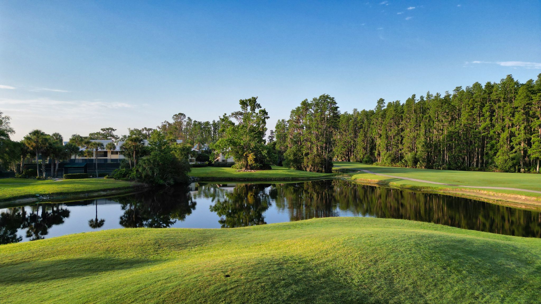 image Tee off against a backdrop of shimmering lakes and rolling fairways.