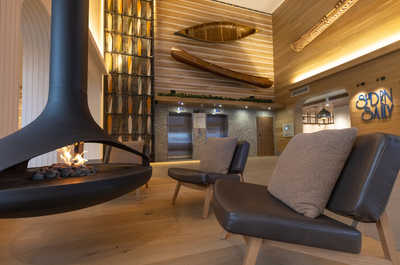 Relax in a lounge featuring a unique, suspended fireplace and soft seating, offering a perfect blend of comfort and contemporary design.