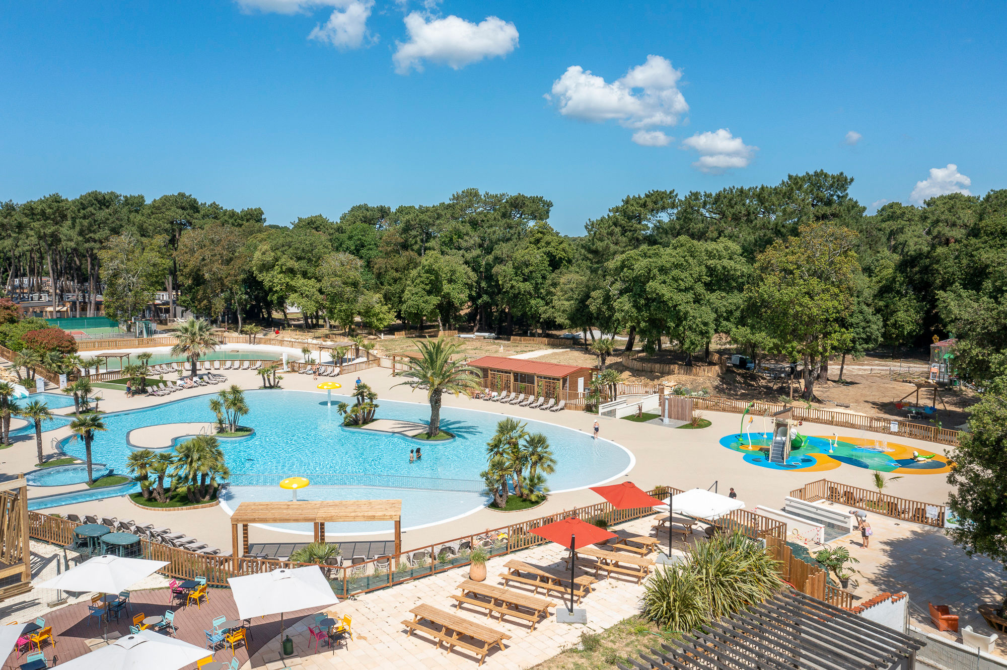 image Relax in the spacious pool area surrounded by lush greenery, the perfect spot to soak up the sun and unwind.