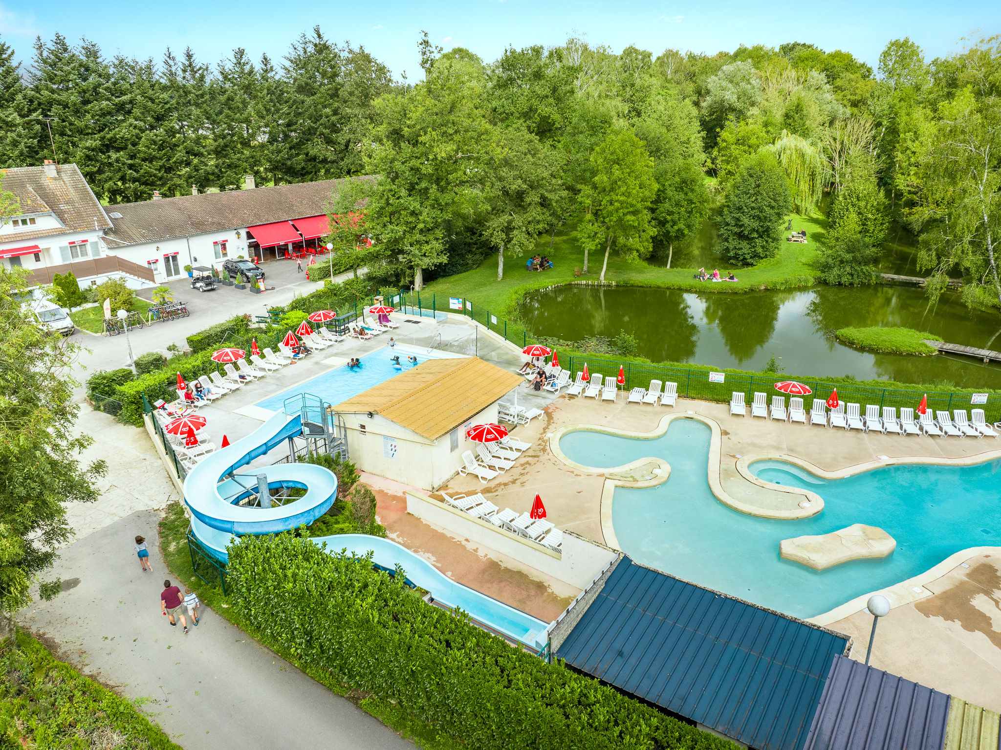 image A vibrant water park nestled in greenery, perfect for a day of fun and relaxation, with plenty of space to soak up the sun.