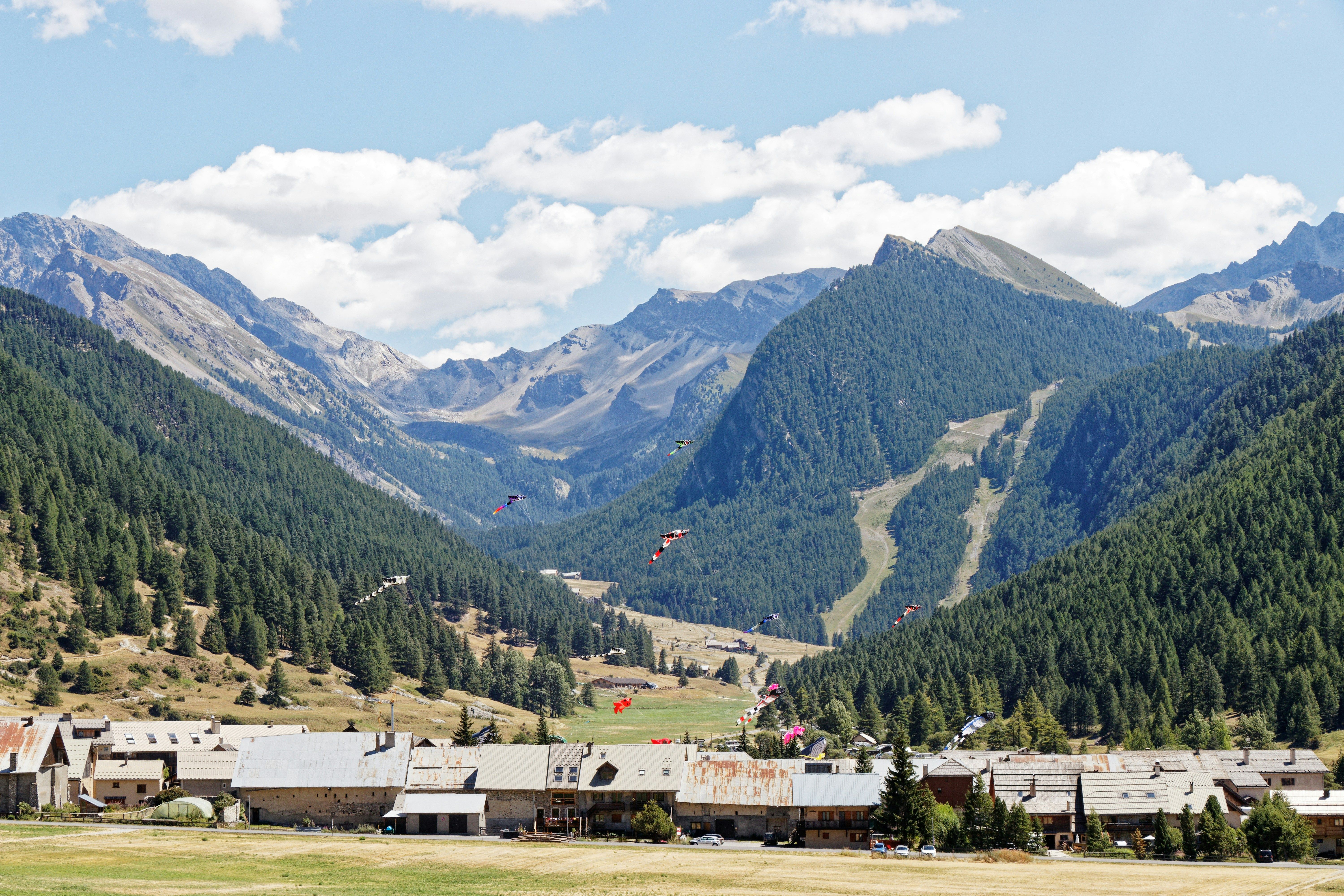 image Paragliders drift over the forested valley below the residence, with the Bergers district just beyond the trees