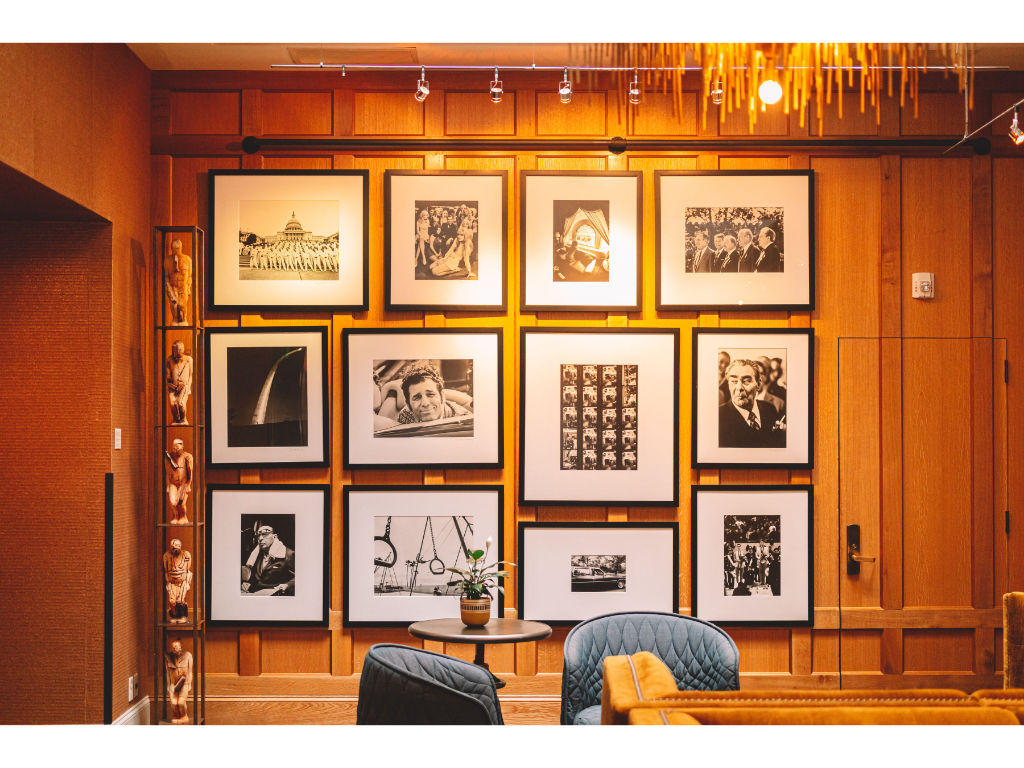 image A wall adorned with an array of framed photographs and art adds a personal touch to our lobby, creating a space that's as much a gallery as it is a welcoming area.