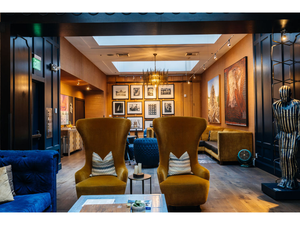 image Our lobby is designed to make a grand statement, featuring dramatic ceilings, plush sofas, and armchairs, all set against a backdrop of dark wood paneling.