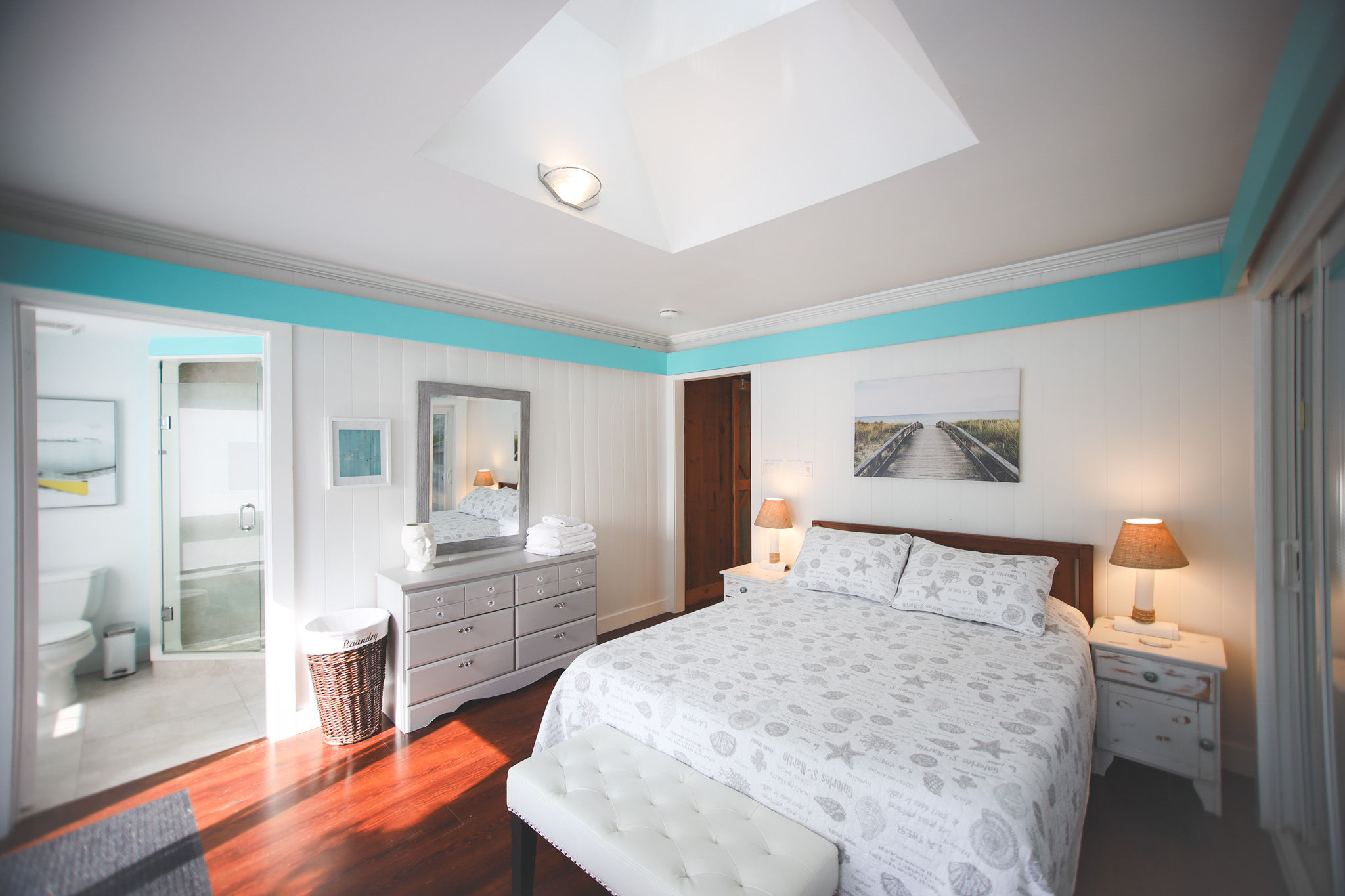 image Unwind in the master bedroom with a queen bed, skylight, and private access to the backyard sitting area.