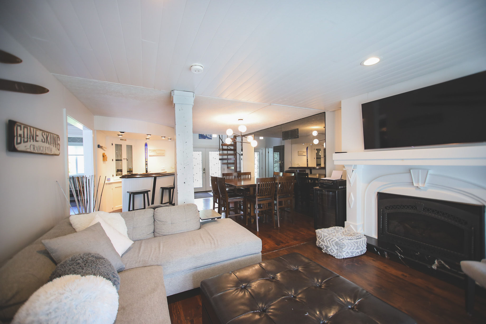image Relax in the inviting living area with a comfy sofa, flat screen TV, gas fireplace, and hardwood floors.