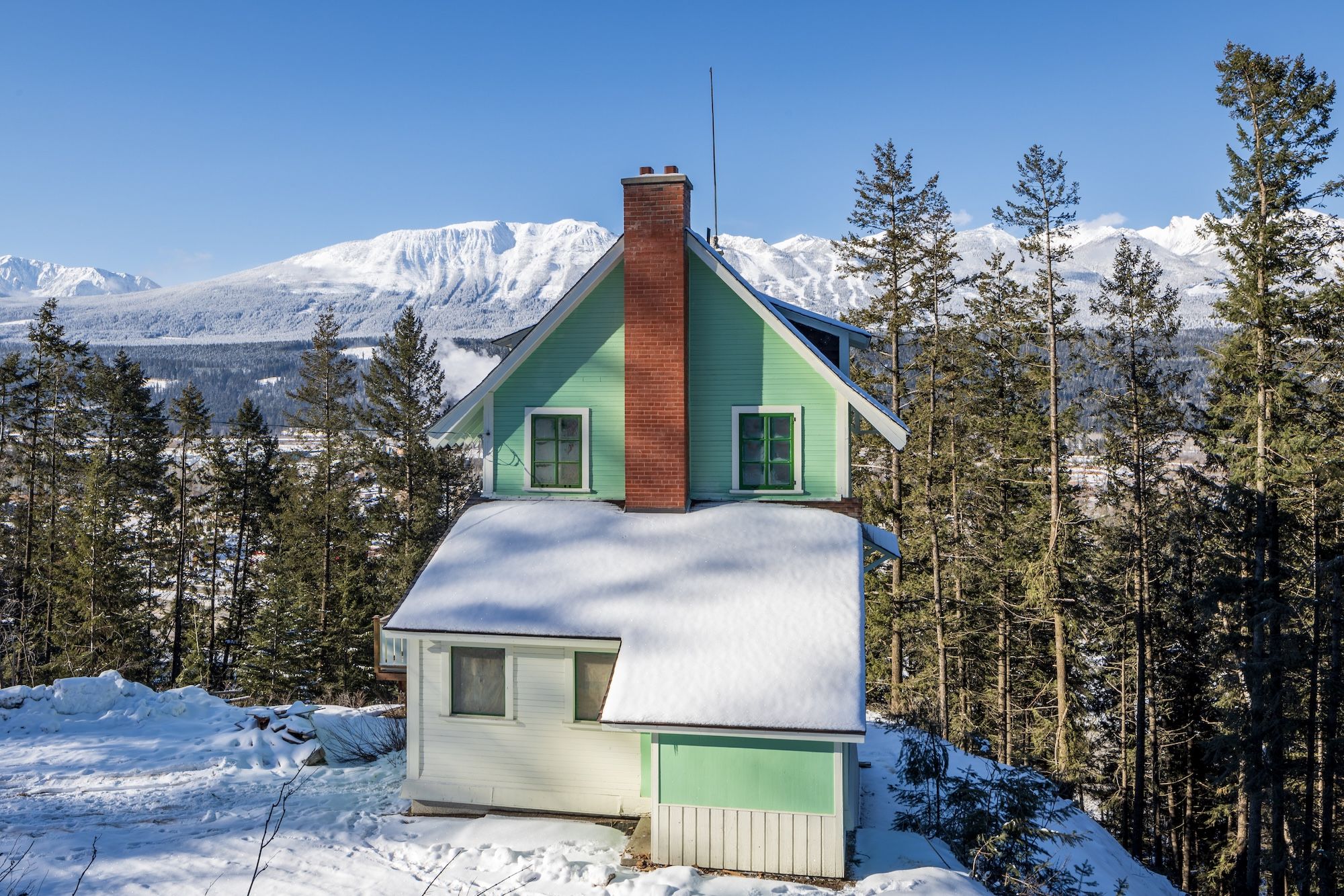 image Enjoy the charming Swiss-style architecture nestled among the snow-covered pines and majestic mountains.