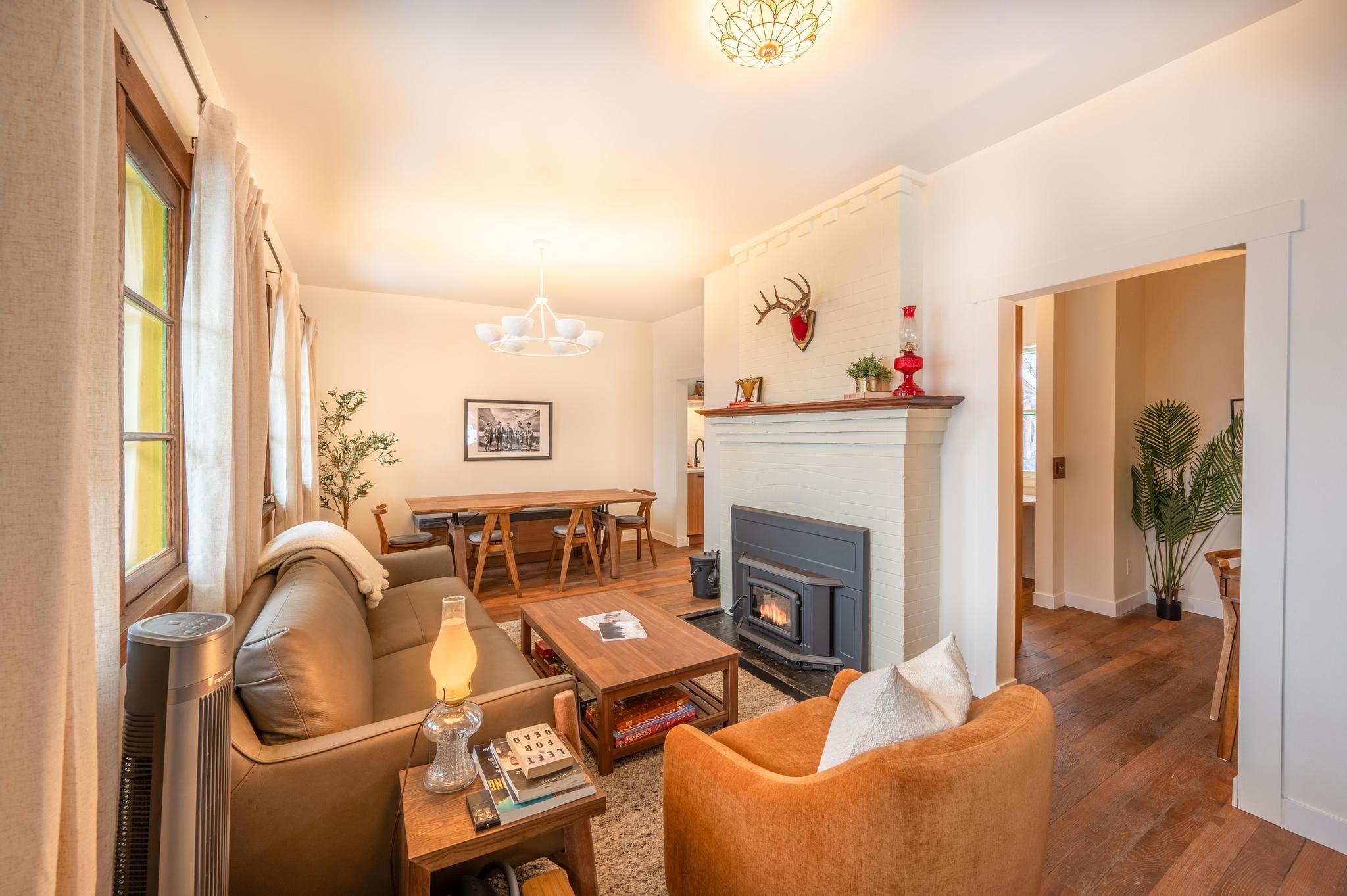 image Cozy living room with warm seating, a crackling wood-burning fireplace, and soft amber lighting—made for evenings in.