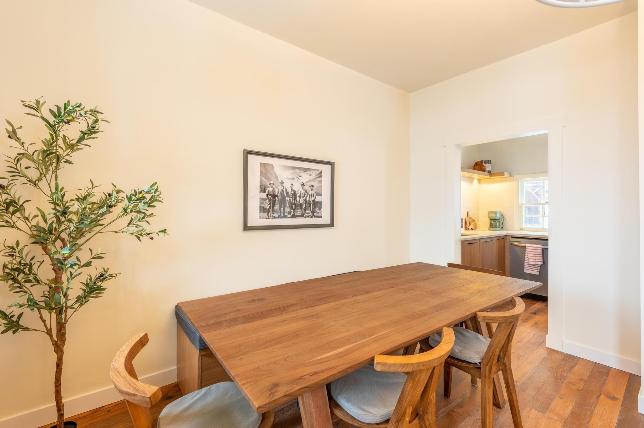 image Charming dining area with a rustic wooden table, surrounded by bright windows and cozy decor for memorable meals.