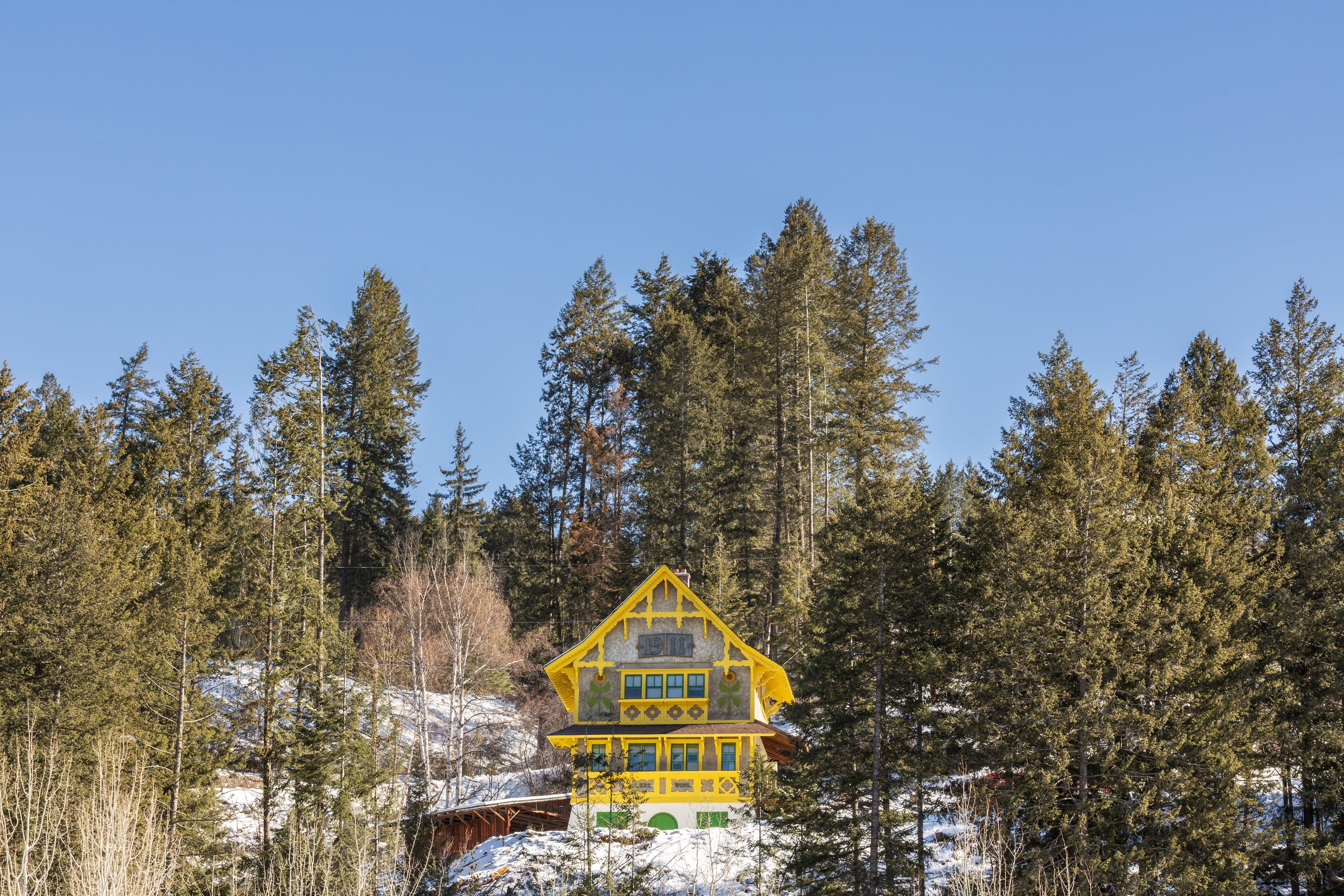 image A wood-clad chalet tucked into the forest, with panoramic mountain views rising beyond the treeline.