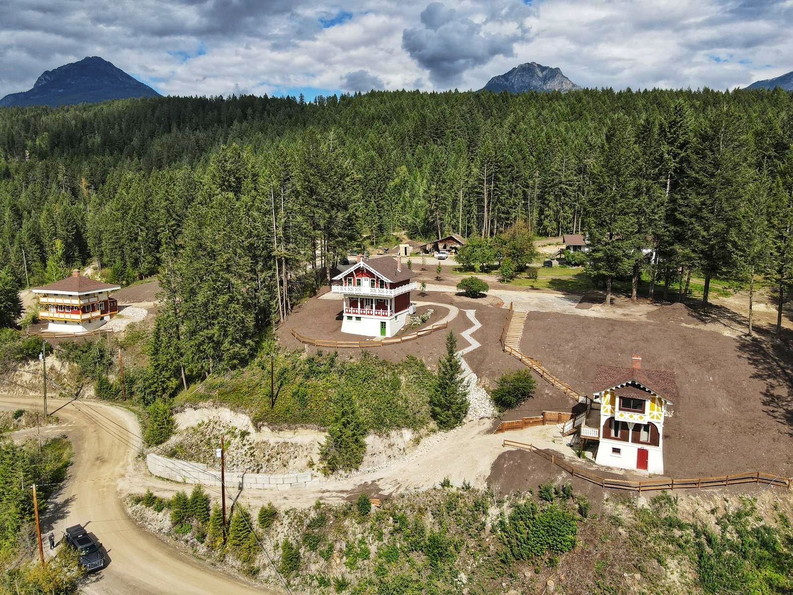 image An aerial view showcases the unique Swiss-style chalets surrounded by towering trees and gentle hills.