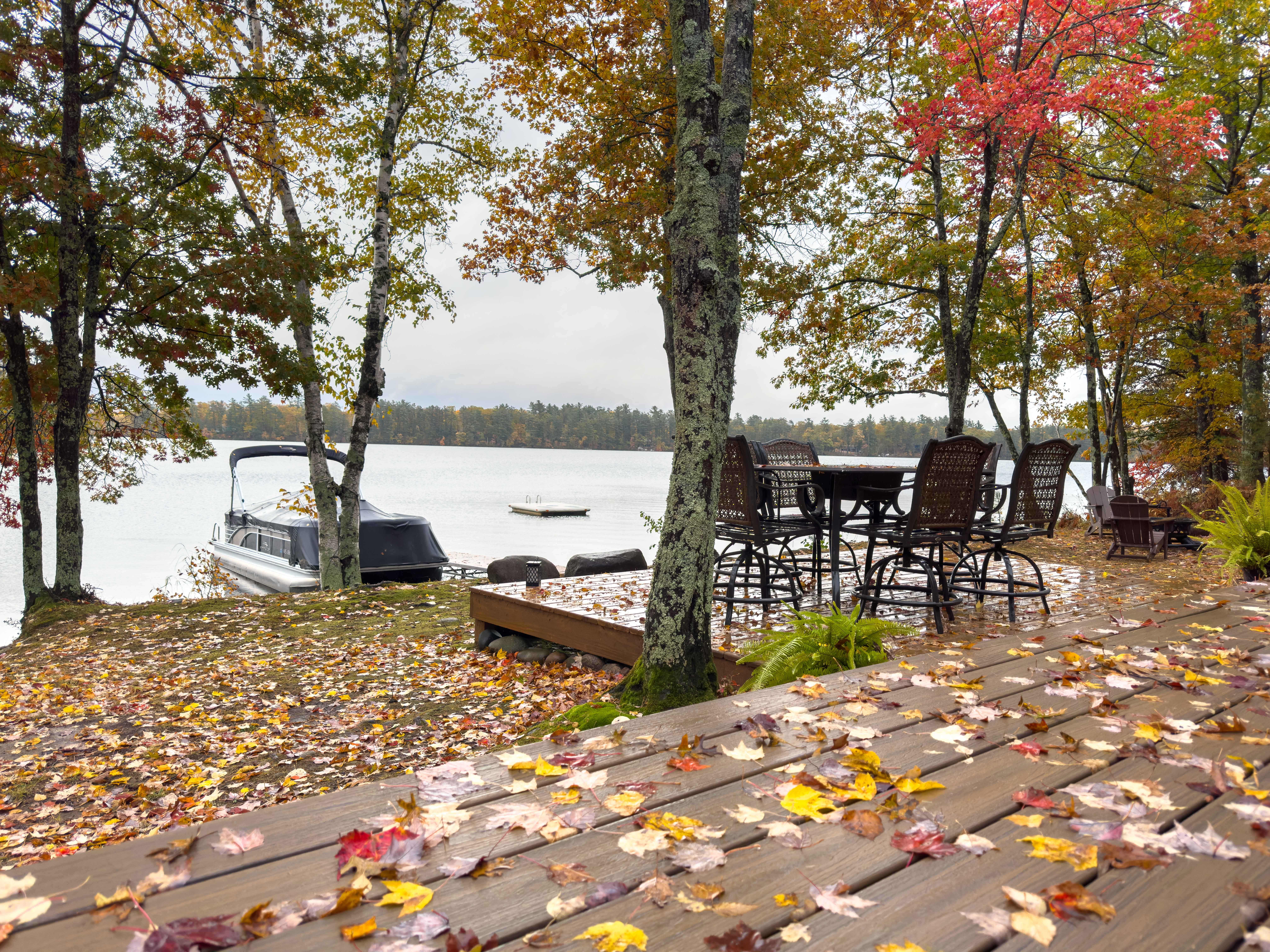 image Lakeside deck with autumn views, outdoor seating, and a private dock on Twin Bear Lake’s pristine waters.