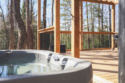 Private hot tub on the deck, ideal for unwinding while enjoying the tranquil forest surroundings.