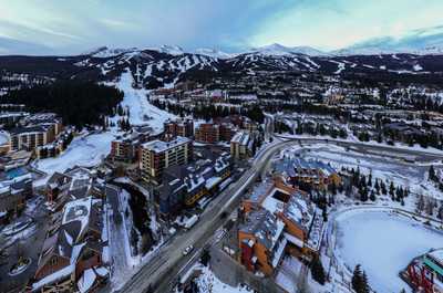 Breathtaking aerial view of a vibrant mountain town, where winter charm meets adventure at every turn.