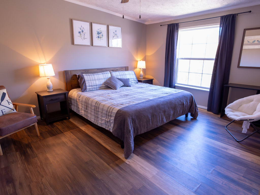 image Rest easy in this welcoming bedroom, designed for relaxation with its soft linens and tranquil ambiance.
