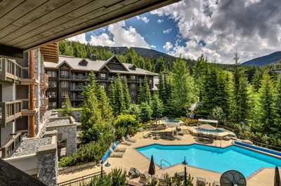 Outdoor pool surrounded by lush greenery—summer relaxation at its best.