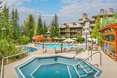 Relax in the hot tub surrounded by summer greenery.