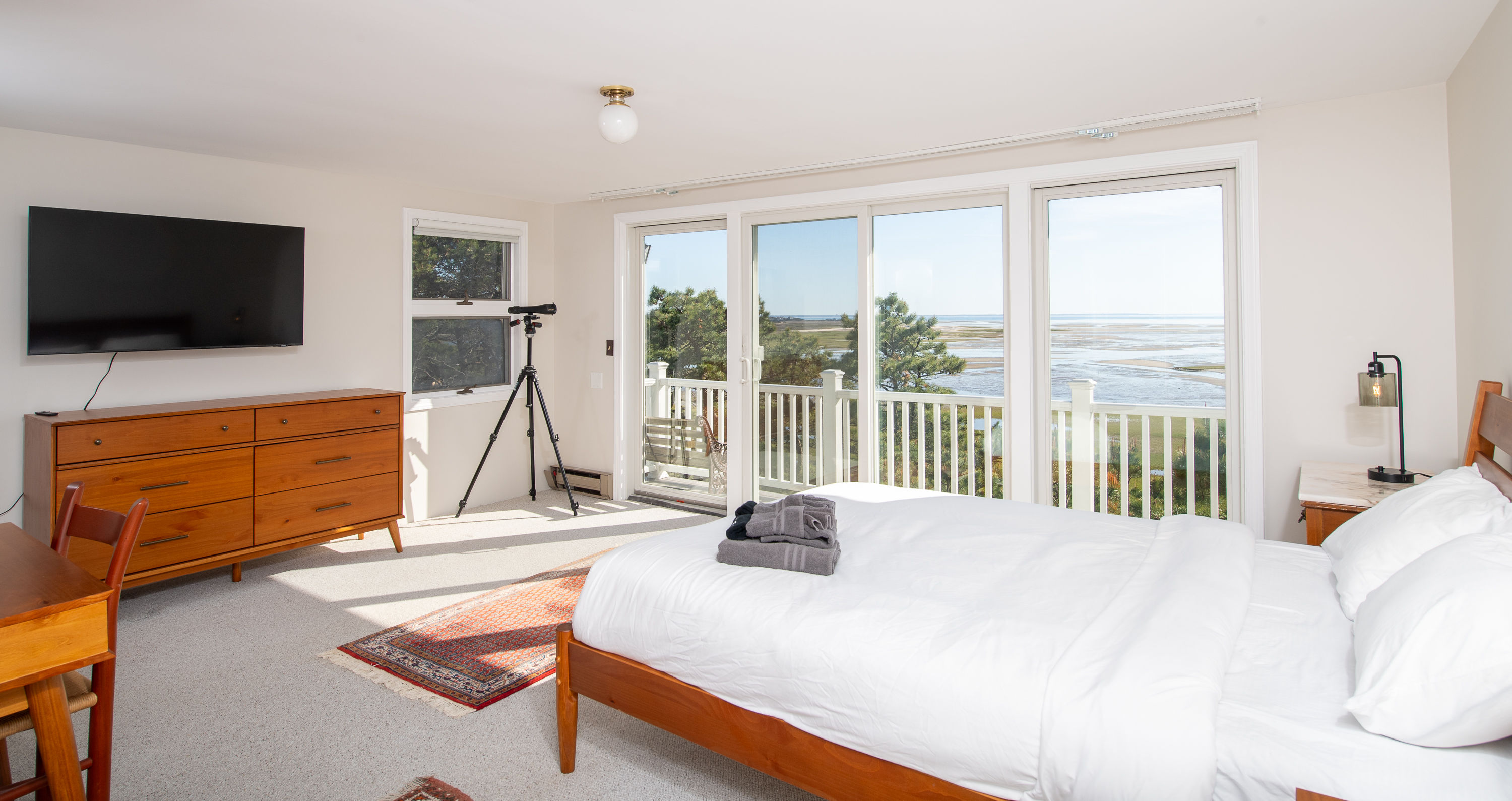 image Spacious bedroom featuring a cozy bed and private balcony with scenic views, perfect for relaxing mornings.