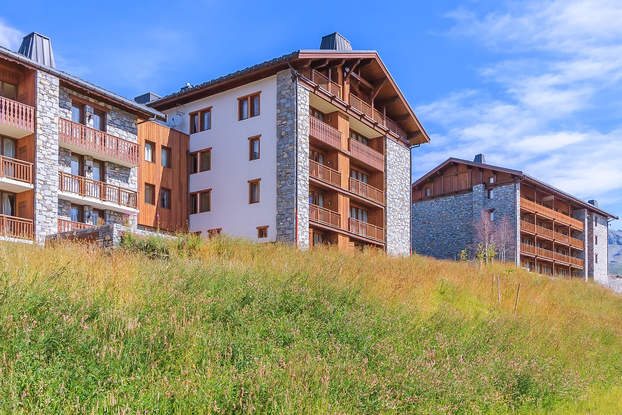 image Surrounded by vibrant green meadows, this mountain retreat invites you to unwind and soak in the peaceful summer landscape.