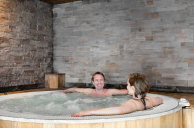 Enjoy a tranquil soak in the hot tub, perfect for unwinding after a day of adventure, while surrounded by the warmth of natural stone.