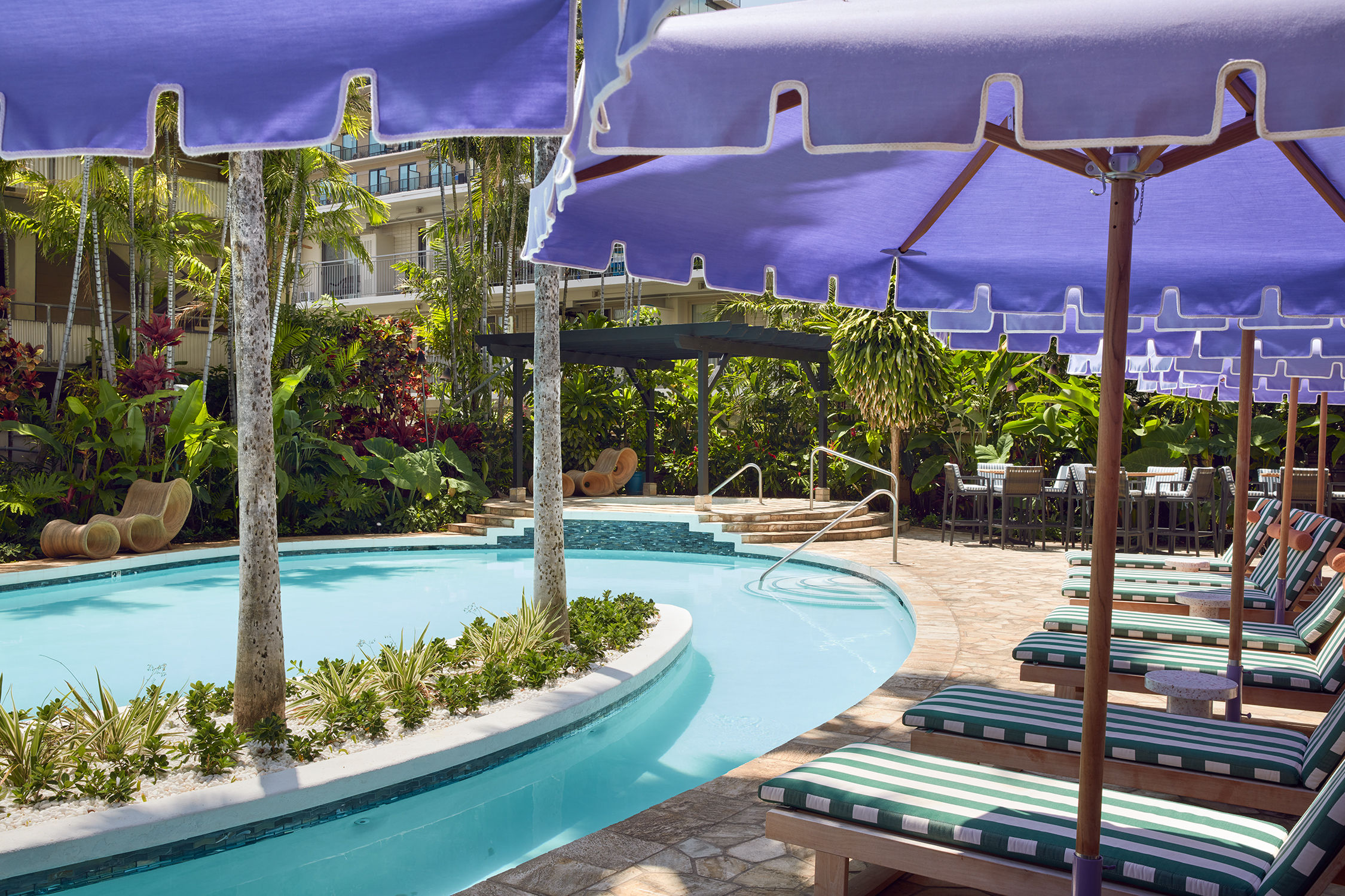 image Bask in the tropical ambiance by the pool, where shaded loungers and lush greenery create the perfect setting for a relaxing day in the sun.