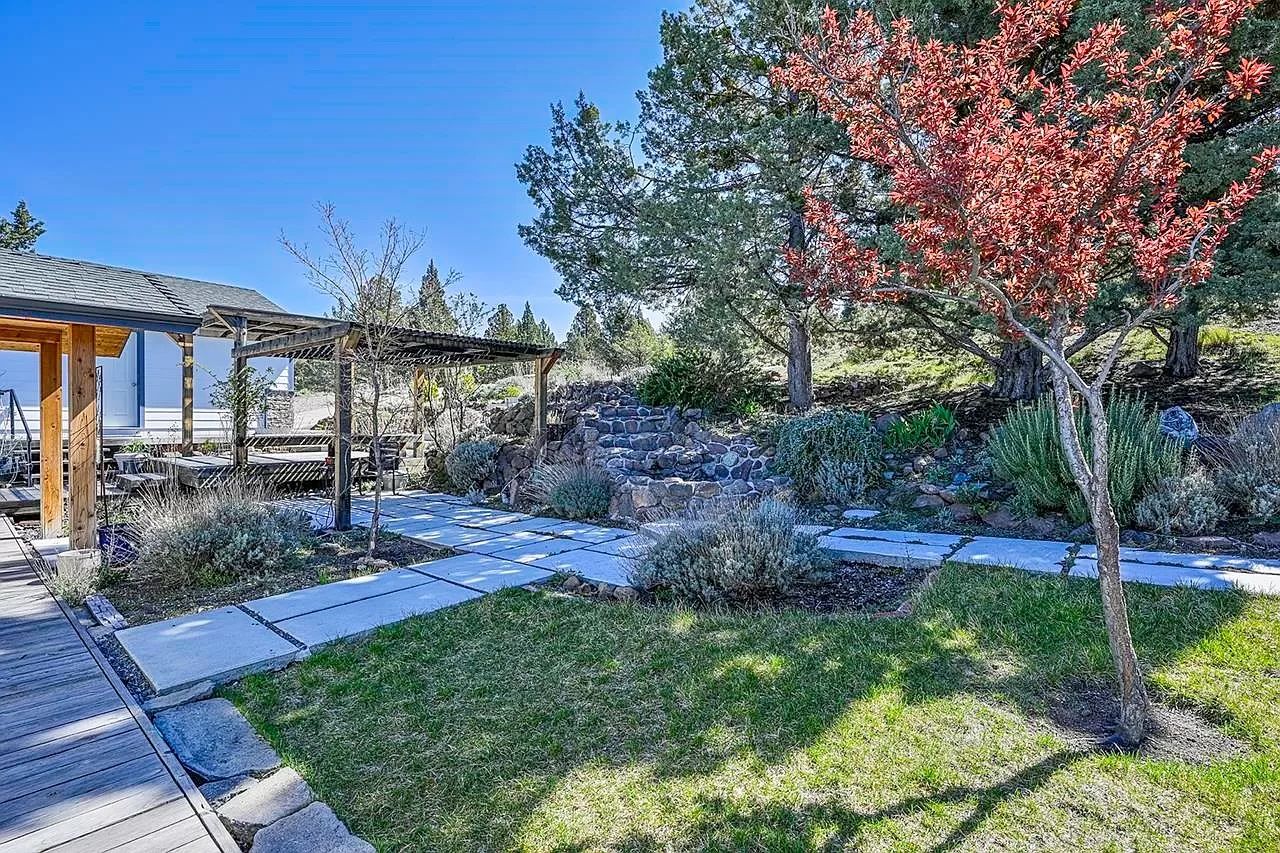 image The porch at the entrance is a perfect blend of comfort and nature, featuring a wooden deck, a lush garden, and a covered space to relax and unwind